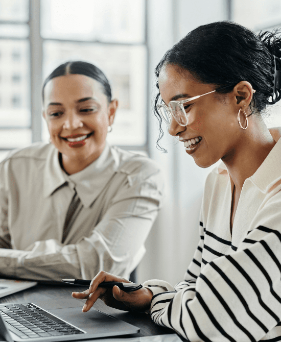Workprofile-Two smiling ladies behind laptop