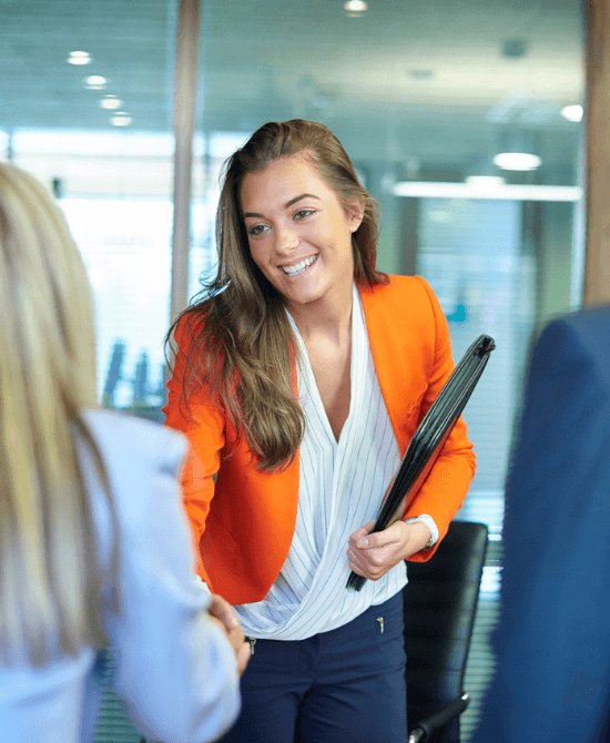 Smiling lady with notebook shaking hands